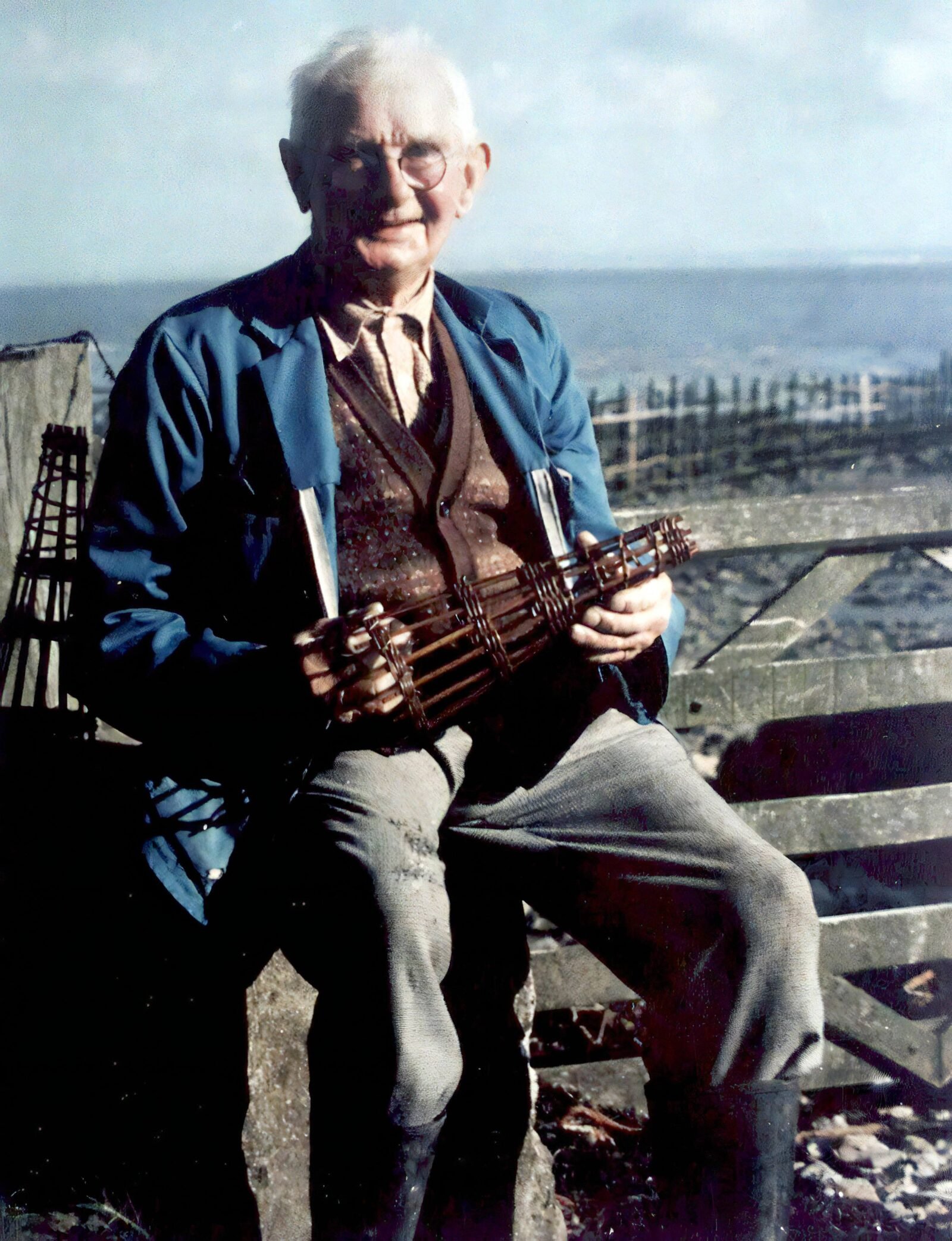 Wyndham Howells holding a small wicker replica of a Putcher (reduced in size)